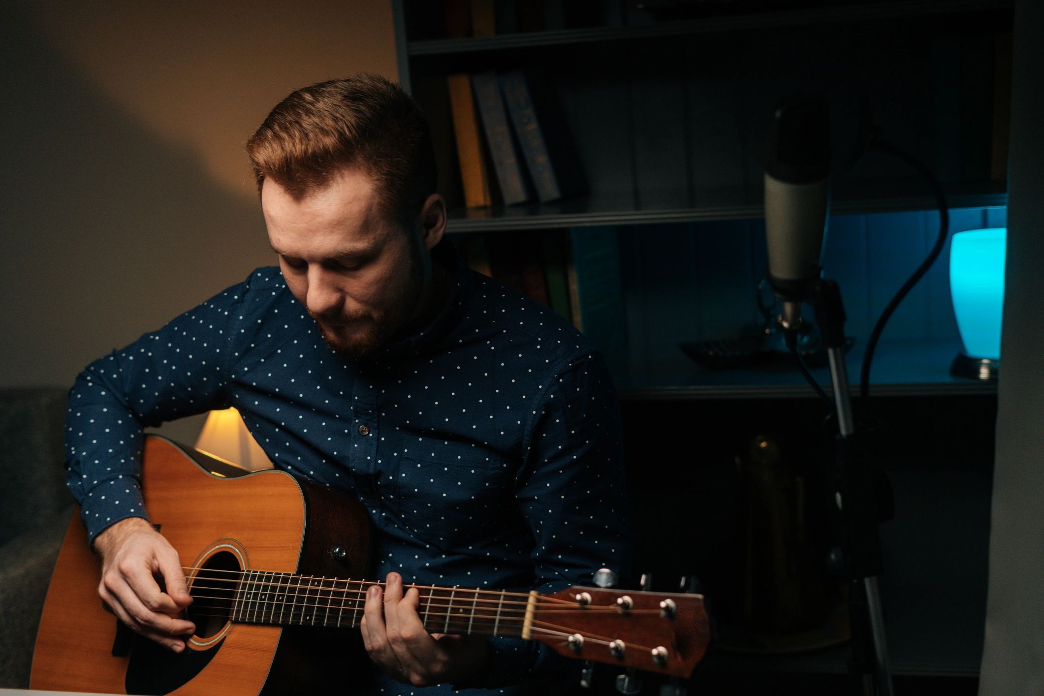 Musician recording guitar and vocals in a home studio
